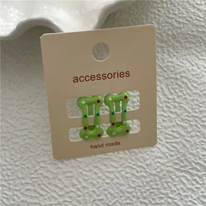Barrettes à cheveux vertes en forme d'os pour enfants avec pois colorés