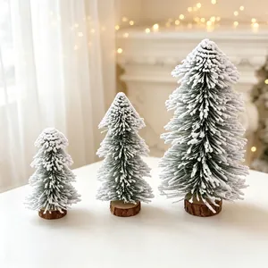 Detailed view of three mini flocked Christmas trees with snow effect and wood bases