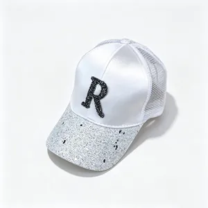 Detailed view of the white satin mesh cap featuring a rhinestone 'R' and sequined brim.