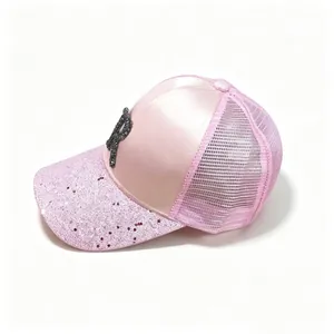 Pink satin baseball cap featuring glittery brim and rhinestone letter R detail view.