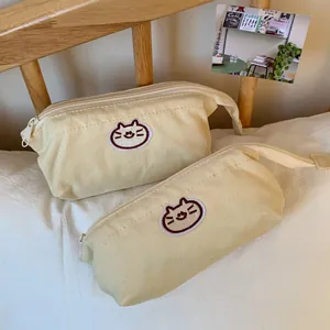 Macro view showing two different sizes of cute cat embroidered cream canvas pencil cases