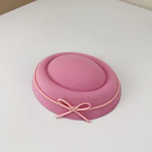 Close-up macro view of a sweet pink felt pillbox hat with a delicate bow detail