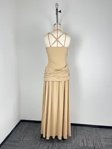 Back view of a tan sleeveless maxi dress with elegant cross-strap design