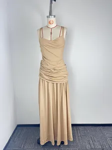 Full detail view of an elegant beige sleeveless ruched maxi dress on a mannequin.