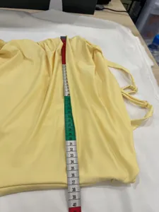 Yellow sleeveless camisole dress length measurement detail shown with soft tape measure