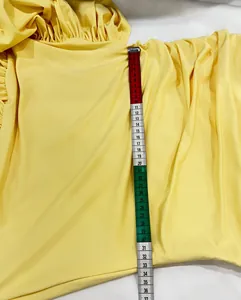 Detail view of yellow sleeveless summer dress with measurement tape showing length
