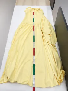 Detail view of a yellow sleeveless maxi dress being measured vertically