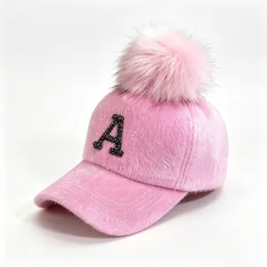 Close-up detail of a pink fuzzy baseball cap featuring a sparkling rhinestone letter A