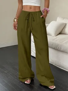 Gros plan d'un pantalon large vert olive avec tissu texturé et taille à cordon