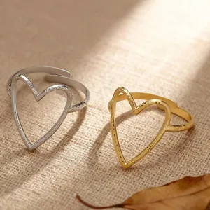 Detailed close-up of adjustable titanium steel hollow heart rings in gold and silver.