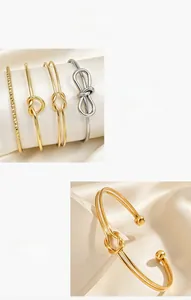 Primo piano macro di un bracciale rigido dorato lucido con nodo e terminali a sfera