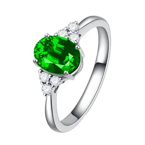 Detaillierte Nahaufnahme eines eleganten Rings mit grünem Edelstein und weißen Steinen