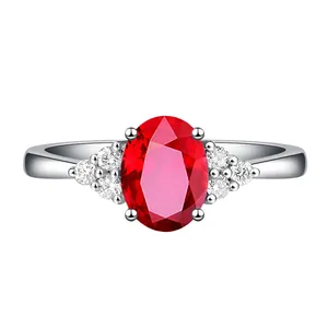 Detailansicht eines eleganten ovalen taubenblutroten Rings mit seitlichen Diamanten