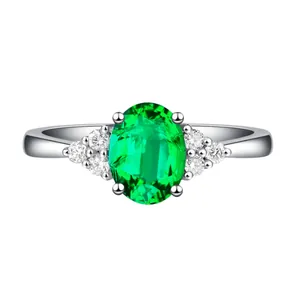 Nahaufnahme eines eleganten Silberrings mit großem ovalem grünem Edelstein und Diamanten.