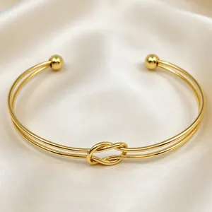Dettaglio ravvicinato che mostra il design del nodo del bracciale in acciaio oro