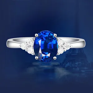 Detailansicht eines eleganten ovalen blauen Saphirrings mit Eiffelturm-Nacht-Hintergrund