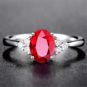 Nahaufnahme eines eleganten ovalen taubenblutroten Edelsteinrings mit Seitensteinen