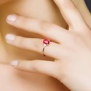 Detailansicht eines eleganten taubenblutroten Rubinrings an einem Frauenfinger