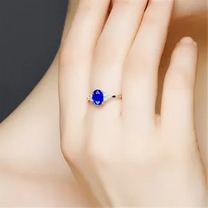 Elegante Nahaufnahme eines ovalen blauen Saphirrings mit feinen Diamanten an der Seite