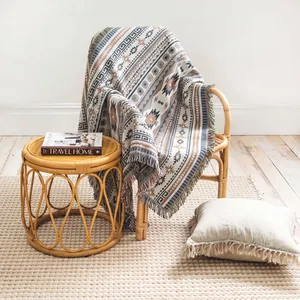 Detailansicht einer gewebten Boho-Decke mit Stammesmustern und Fransen auf einem Sessel