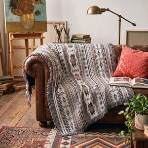 Gewebte Boho-Decke mit Ethno-Muster auf einem Ledersofa dekoriert