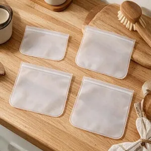 Sacs de conservation givrés réutilisables pour aliments sur une surface de cuisine en bois