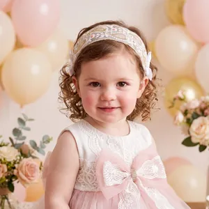 Close-up of toddler girl wearing an elegant white lace headband with floral embroidery