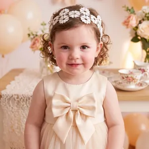 Close-up of white lace flower headband on a toddler girl for an elegant party look.