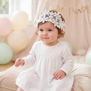 Detailed shot of white lace flower headband on a baby girl during a first birthday party