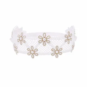 Detailed macro view of kids white lace headband featuring embroidered daisies and pearls