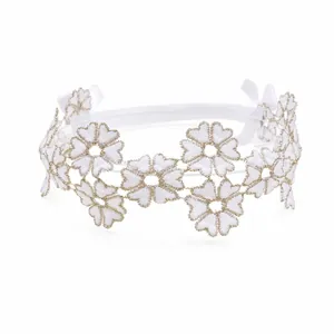 Detailed view of a delicate white floral lace headband with gold trim accents for baby girls