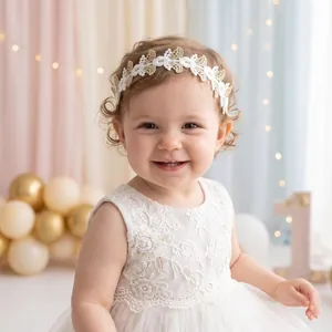 Gros plan d'un bébé portant un magnifique bandeau en dentelle florale blanche et or