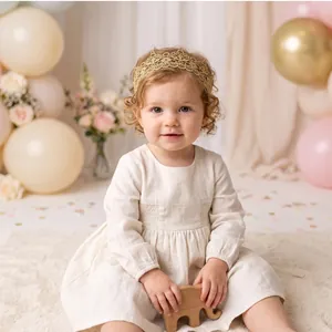 Détail d'un bandeau couronne en dentelle dorée pour bébé fille dans un décor de studio