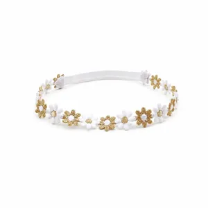 Détail de fleurs brodées blanches et dorées sur un bandeau élastique pour bébé