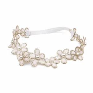 Vue détaillée du bandeau en dentelle pour bébé avec des fleurs brodées et perles