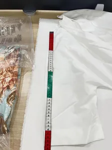 Dettaglio della misurazione che mostra la lunghezza della manica di una tuta bianca