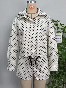 Close-up view of a white polka dot jacket set displayed on a mannequin torso