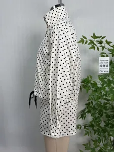 Detailed side view of white polka dot jacket with stand collar on a mannequin