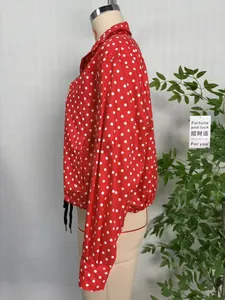 Detailed side view of a red women's baseball jacket with classic white polka dot print