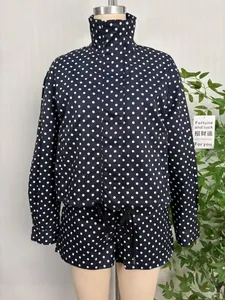 Close-up of navy blue polka dot jacket suit with stand collar and drawstring hem