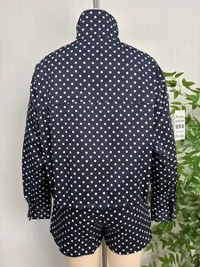 Back view of a navy blue polka dot women's jacket with stand collar and loose fit