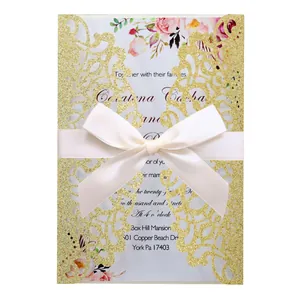 Close-up of gold glitter laser-cut wedding invitation card with elegant cream bow