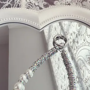 Close-up of luxury phone strap with pearls and sparkling rhinestone details