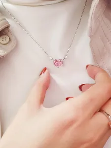 Elegante herzförmige Halskette mit rosa Stein an einer silbernen Kette am Modell