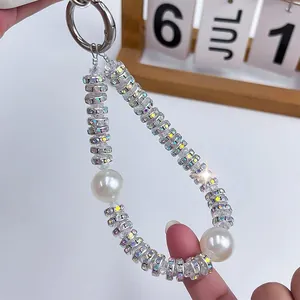 Luxury phone charm featuring sparkling rhinestone beads and elegant large white pearls.