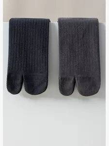 Close-up detail of premium ribbed cotton split-toe tabi socks in black and grey