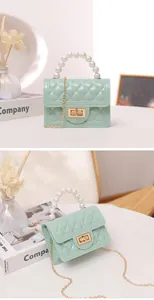 Detailed view of a mint green quilted jelly bag with a faux pearl handle and gold chain.