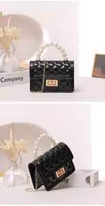 Detail view of a black quilted jelly bag featuring a pearl handle and gold hardware
