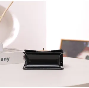 Macro detail view of a black glossy silicone jelly handbag with gold-tone hardware clasp