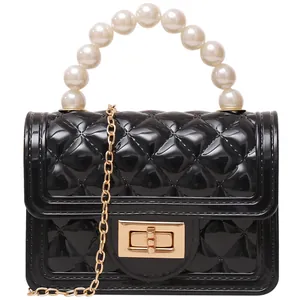 Mini black quilted jelly bag featuring an elegant pearl handle and golden chain strap